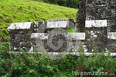 Lichen covered crenelated outer stone wall Stock Photo